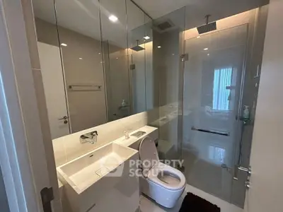 Modern bathroom with glass shower and sleek fixtures in a contemporary apartment.