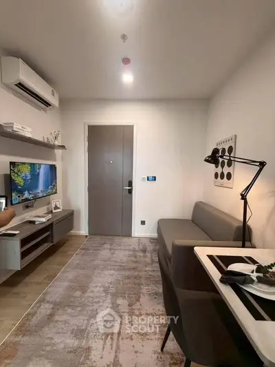 Modern living room with sleek furniture and wall-mounted TV, perfect for cozy urban living.