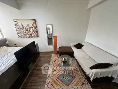 Modern living room with stylish decor and cozy seating area, featuring a large wall art and sleek flooring.