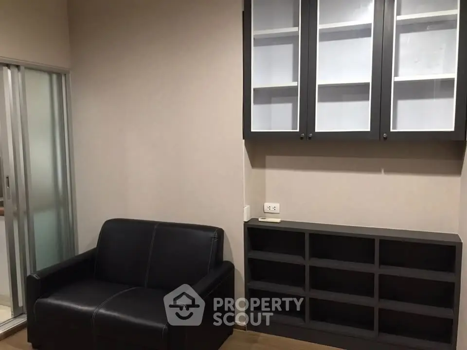 Modern living room with sleek black sofa and stylish storage cabinets.