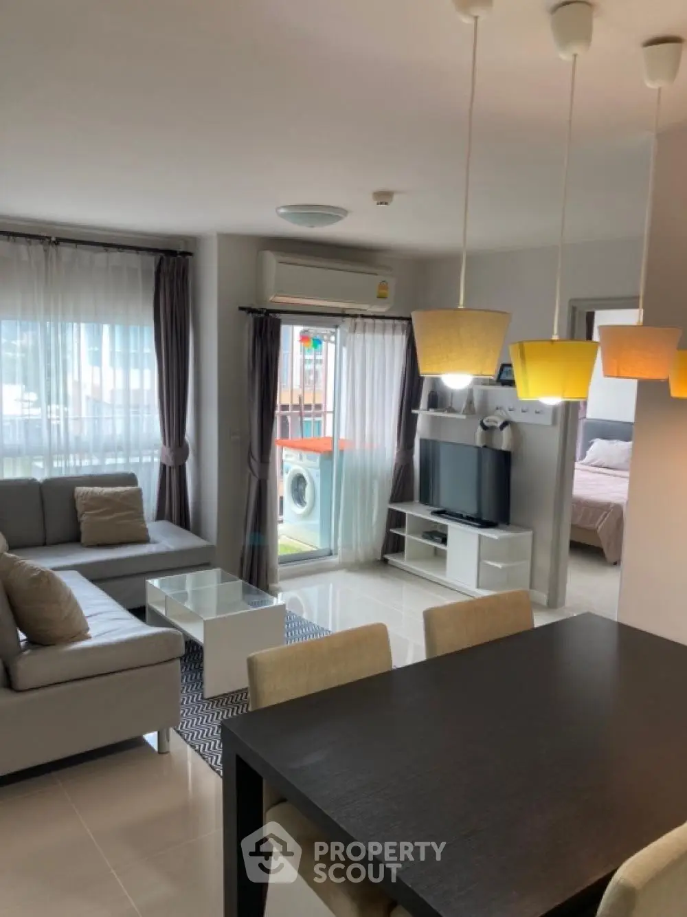 Modern living room with stylish decor and natural light, featuring a cozy seating area and dining space.