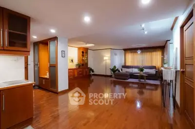 Spacious living room with wooden flooring and modern decor, perfect for family gatherings.