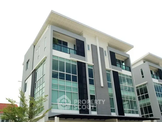 Modern multi-story building with large windows and sleek design.