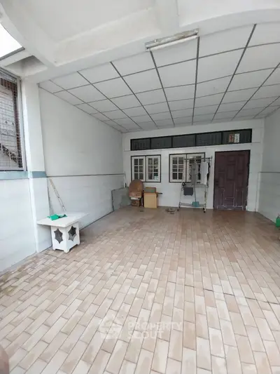 Spacious tiled garage with ample storage potential and natural light.
