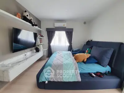 Modern bedroom with stylish decor, featuring a cozy bed, wall-mounted TV, and elegant shelving.