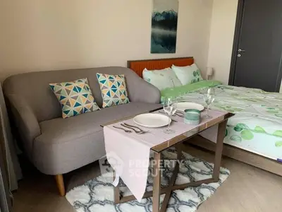 Cozy bedroom with stylish sofa and dining setup, perfect for modern living.