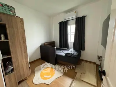 Cozy bedroom with modern furniture and air conditioning, featuring a unique egg-shaped rug for added charm.
