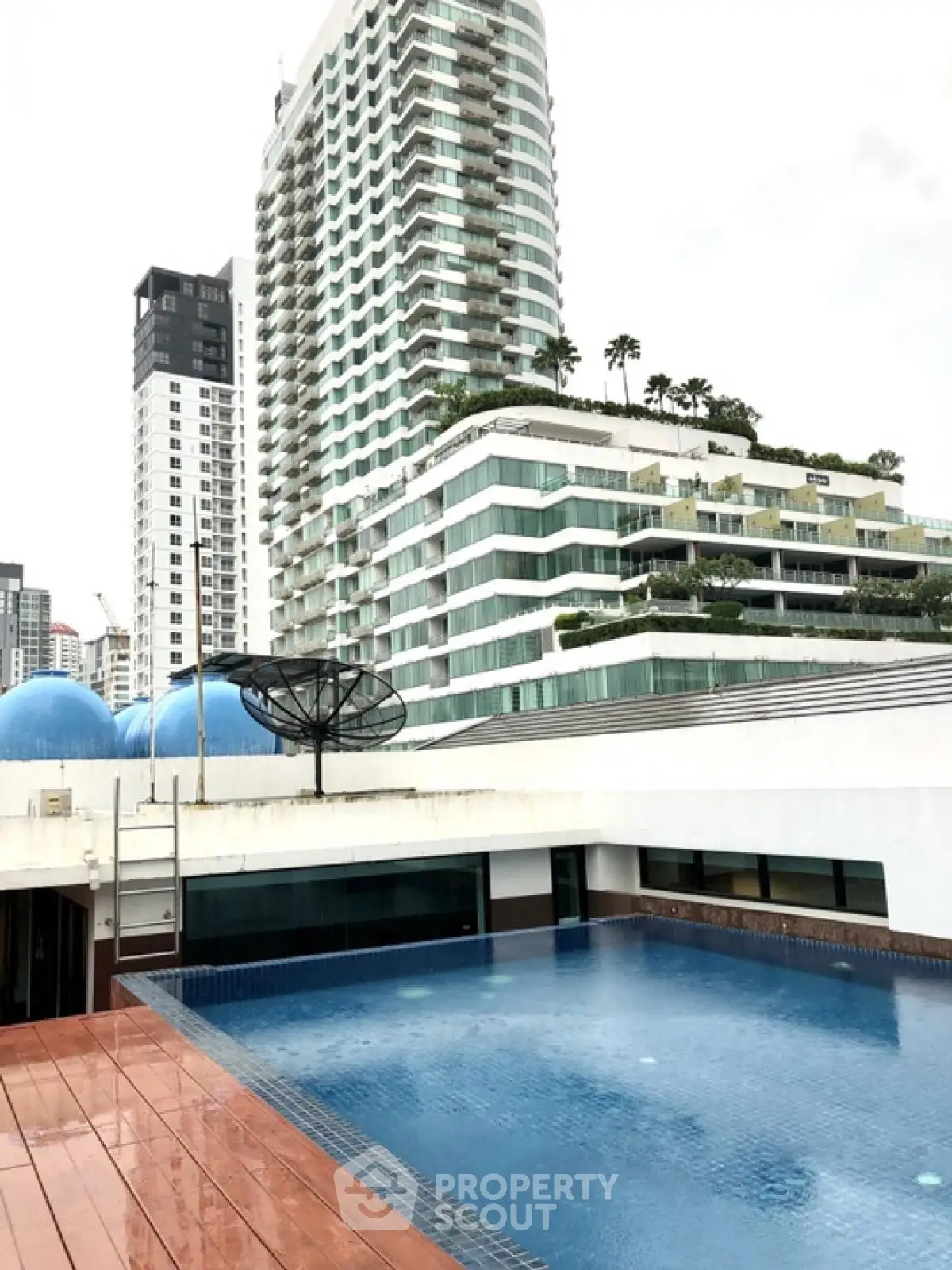 Luxurious rooftop pool with stunning cityscape views in modern high-rise building.