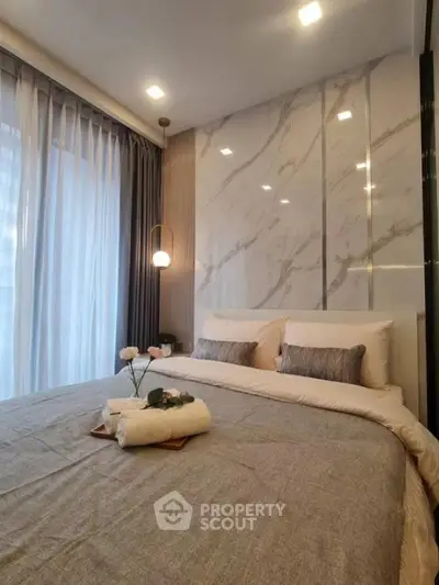 Luxurious bedroom with marble accent wall and cozy lighting