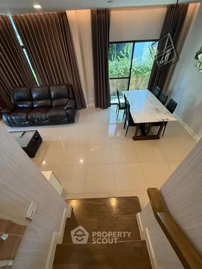 Elegant living and dining area with modern decor and large windows