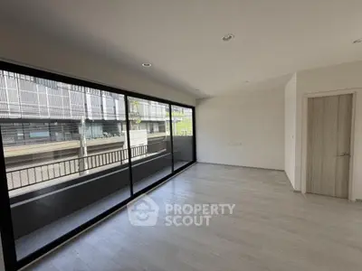 Spacious modern living room with large windows and balcony view