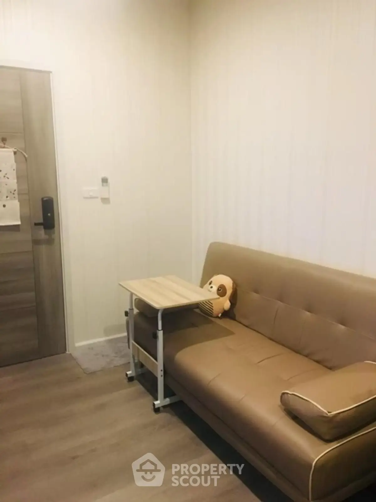 Cozy living room with modern sofa and wooden flooring, perfect for relaxation.