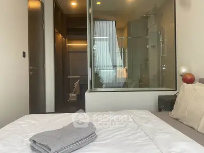 Modern bedroom with glass-walled bathroom and cozy decor