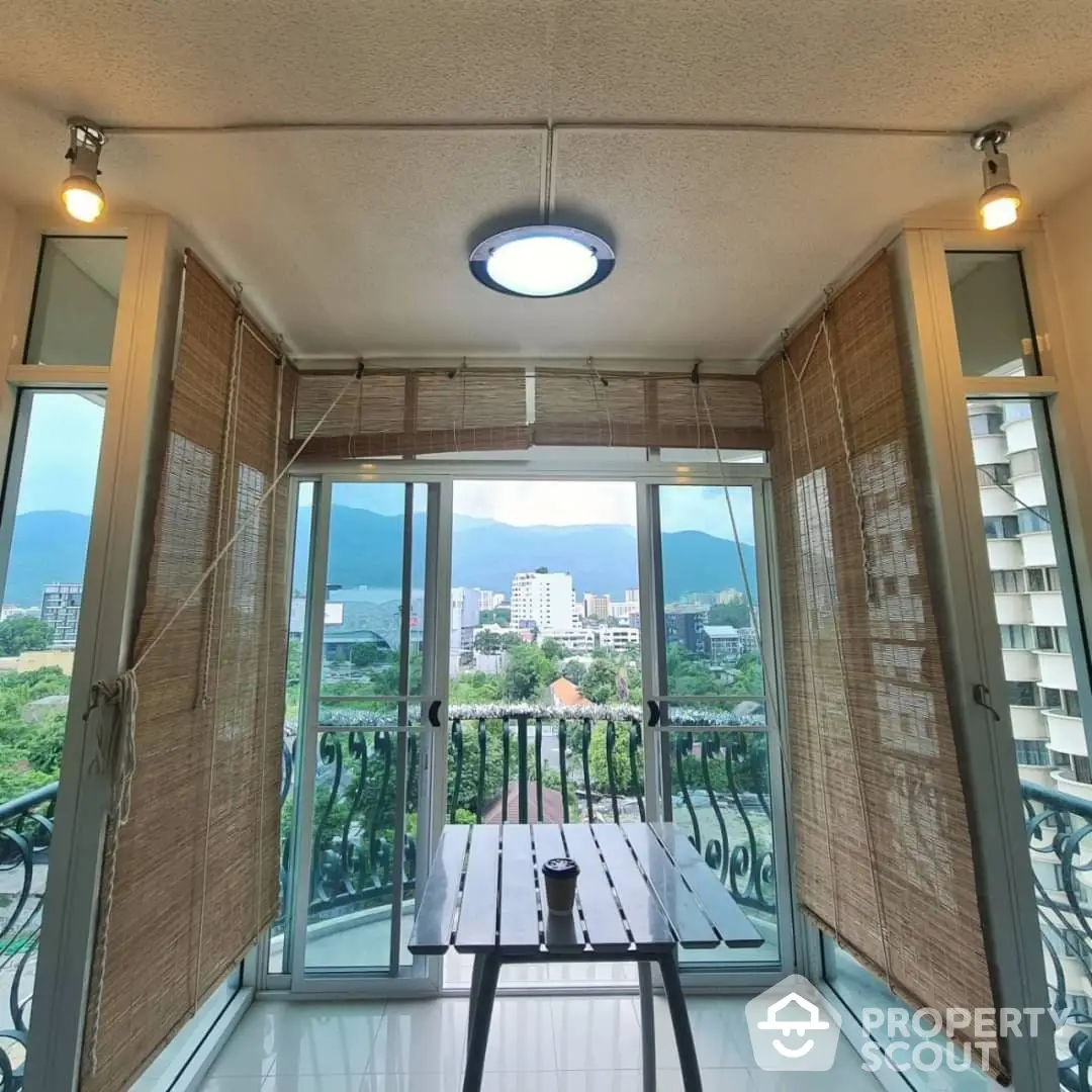 Spacious balcony with a stunning panoramic view of the cityscape and lush mountains, perfect for al fresco dining and relaxation.