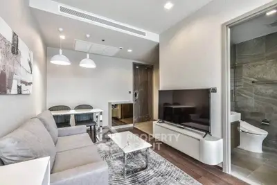 Modern living room with sleek furniture and open layout, featuring a cozy dining area and stylish decor.