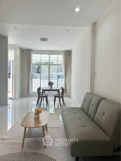 Spacious living room with modern decor and natural light, perfect for relaxation and entertaining.