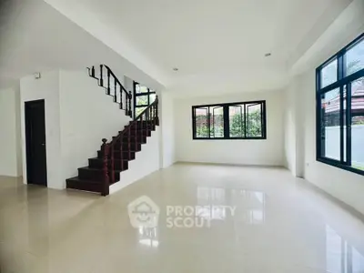 Spacious modern living room with staircase and large windows