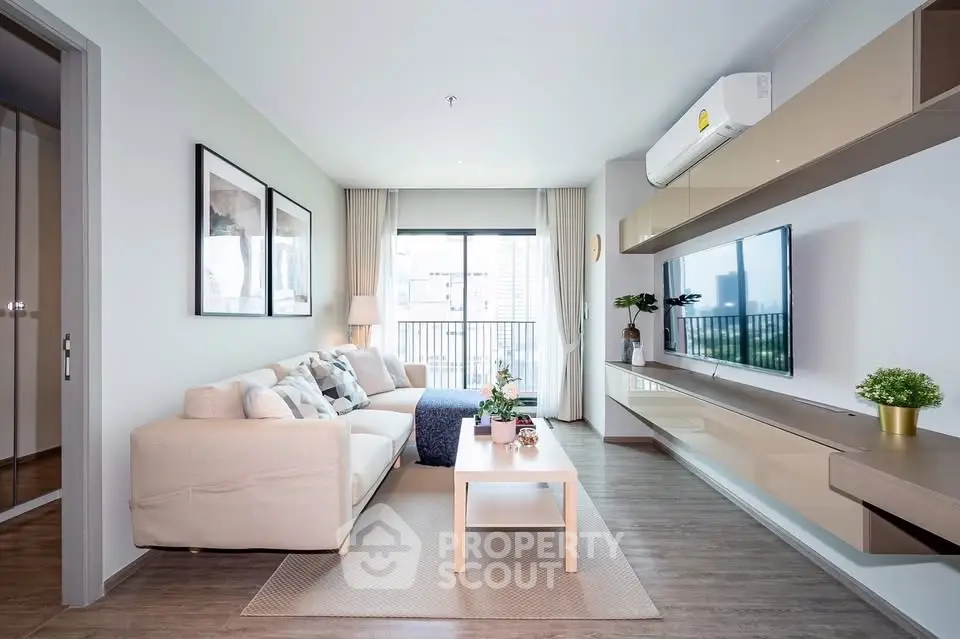 Modern living room with stylish decor and balcony view in a contemporary apartment.
