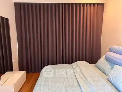 Cozy bedroom with elegant curtains and stylish bedding in modern apartment.