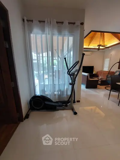 Spacious living area with exercise equipment and modern decor