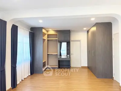 Spacious modern bedroom with elegant built-in wardrobes and large windows for natural light.