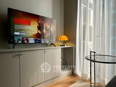 Modern living room with TV, sleek cabinet, and floor-to-ceiling windows.