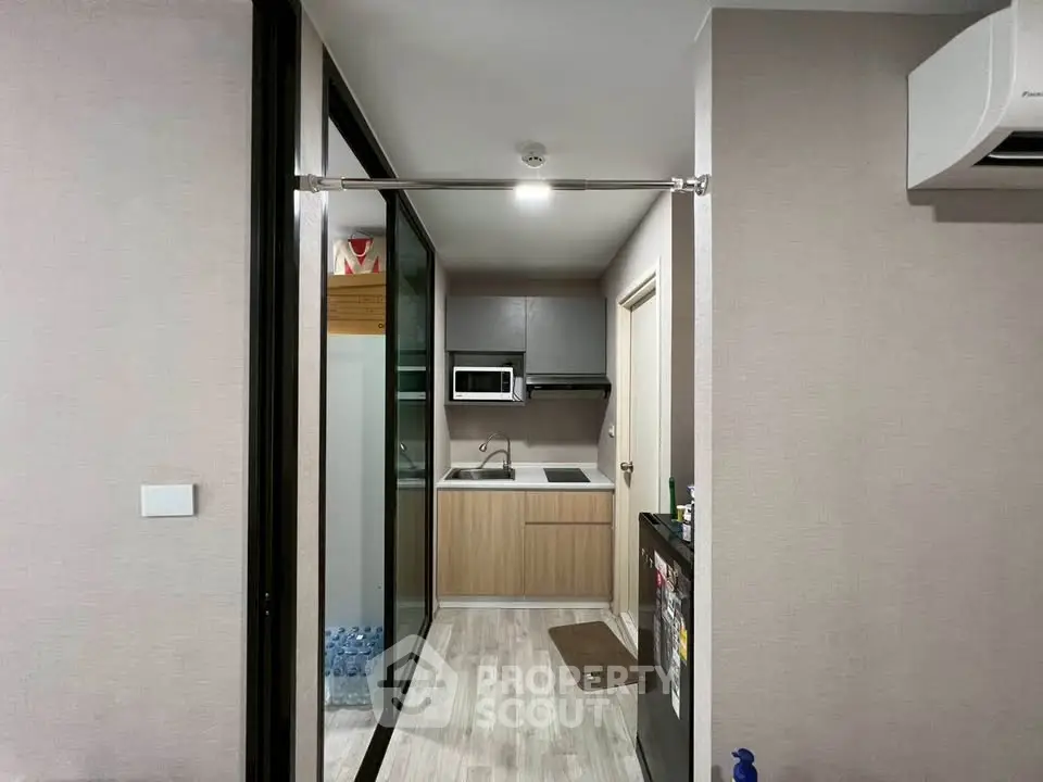 Modern compact kitchen with sleek cabinetry and built-in microwave