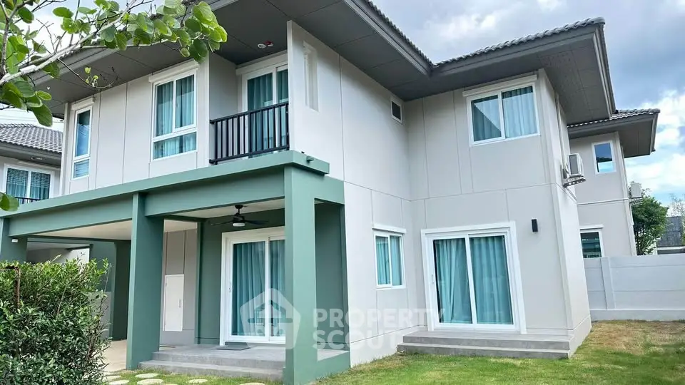 Modern two-story house with large windows and lush garden, perfect for family living.