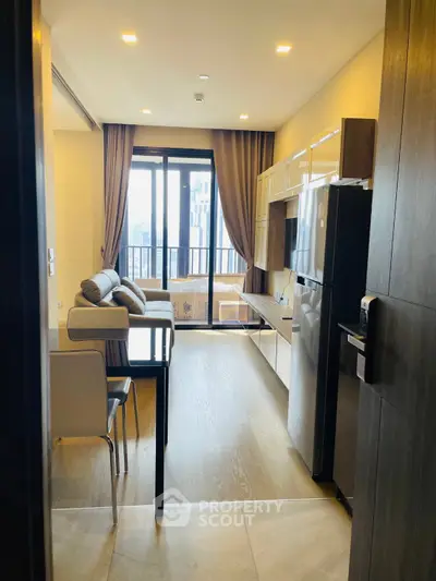 Modern living room with balcony view, sleek furniture, and open layout in a high-rise apartment.