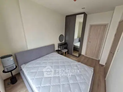 Modern bedroom with stylish furniture and ample natural light, featuring a comfortable bed and sleek wardrobe.