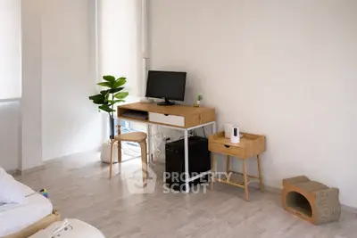 Modern study room with sleek desk, computer, and stylish decor in bright apartment.