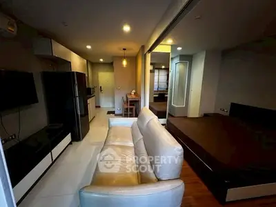 Modern studio apartment with open layout, featuring a cozy living area and sleek kitchen design.