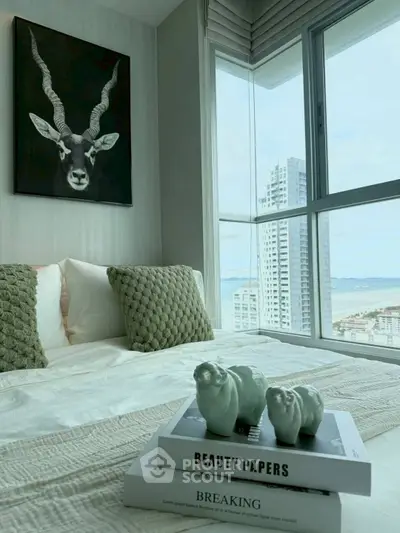 Stylish bedroom with modern decor and stunning city view from large window.