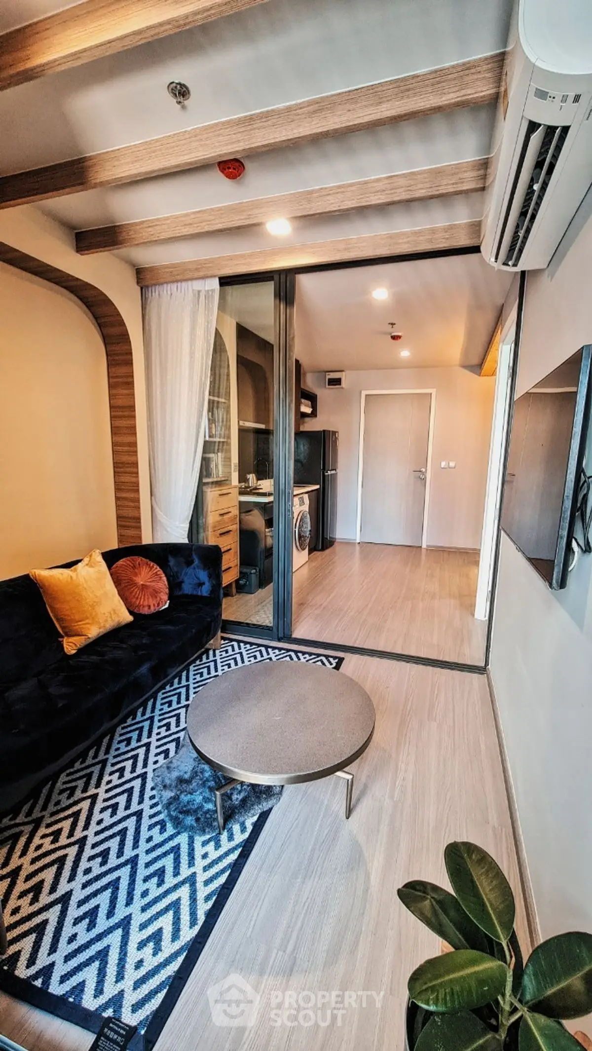 Modern living room with stylish decor and open layout, featuring a cozy sofa and sleek flooring.