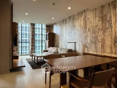 Modern living room with stylish decor and large windows offering city views, featuring a cozy seating area and dining table.