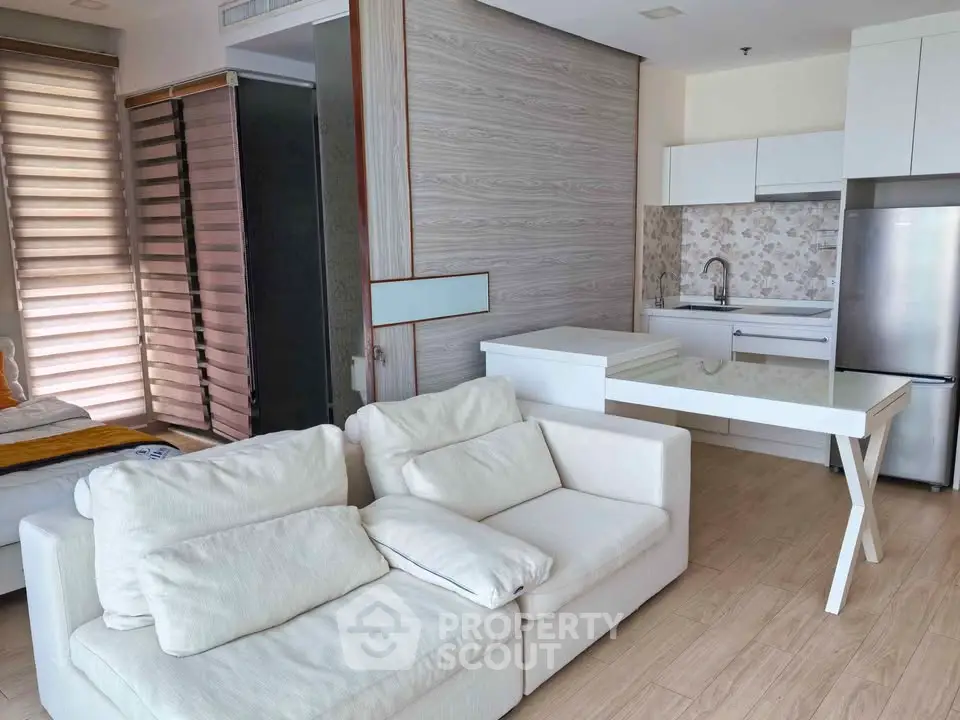 Modern open-plan living room with sleek kitchen and cozy seating area