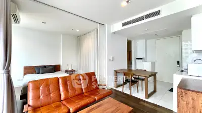 Modern studio apartment with open layout, featuring a cozy living area and stylish kitchen.