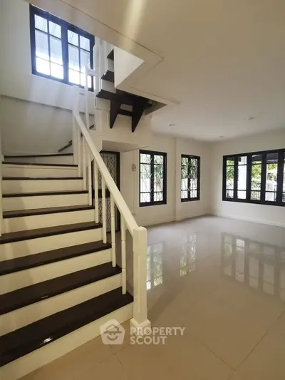 Spacious modern interior with elegant staircase and large windows