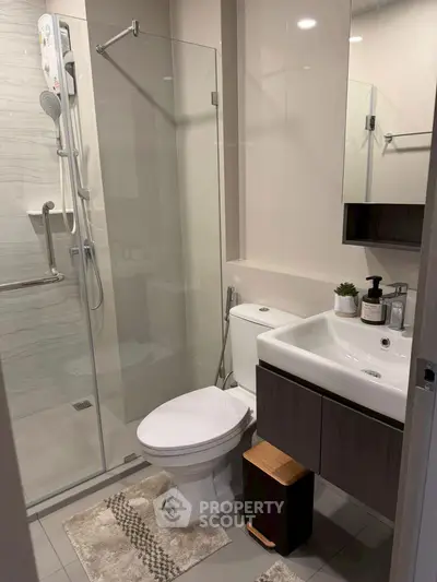 Modern bathroom with glass shower and sleek fixtures in a contemporary home.