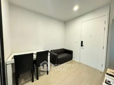 Modern minimalist living room with compact sofa and dining table in a cozy apartment.