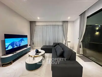 Luxurious modern living room with sleek furniture and large TV, perfect for relaxation.