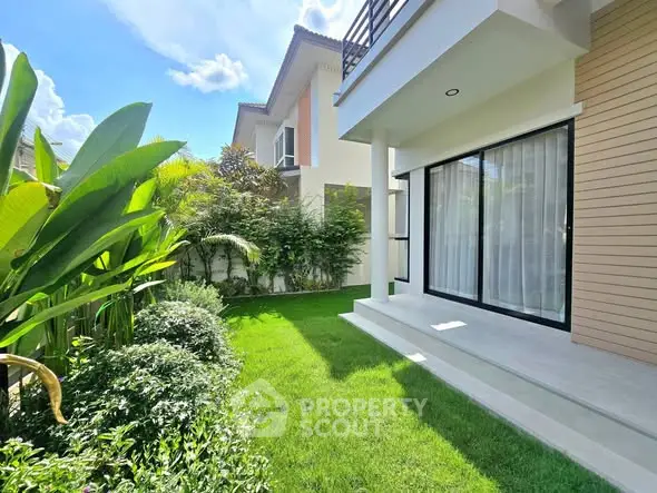 Beautiful garden view of modern home with lush greenery and large windows.