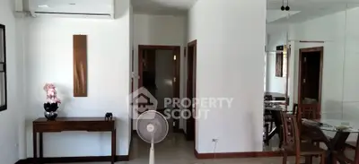 Spacious living area with modern decor and dining set, featuring air conditioning and elegant furnishings.