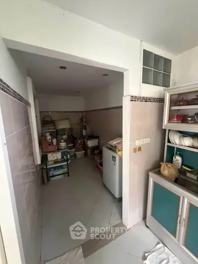Compact kitchen with closed layout and essential appliances in a cozy home setting.
