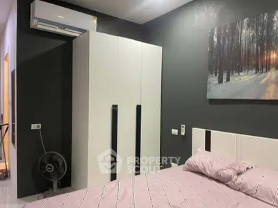 Modern bedroom with sleek wardrobe and air conditioning, featuring a serene forest artwork.