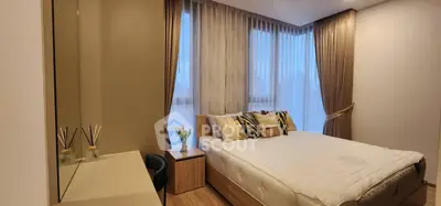 Elegant bedroom with large windows and modern decor in a luxurious apartment.