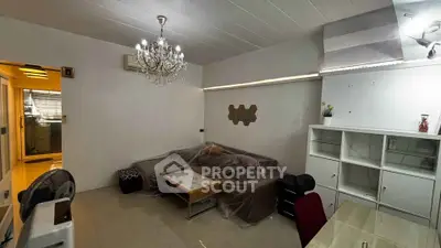 Cozy living room with chandelier and modern furniture, perfect for relaxation.
