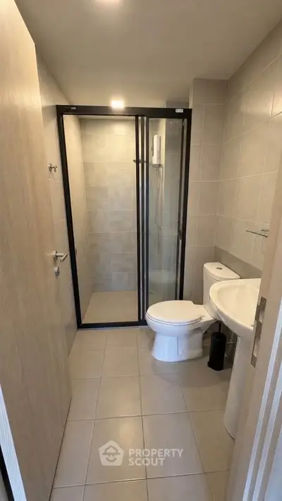 Modern bathroom with glass shower and sleek fixtures in a contemporary apartment.