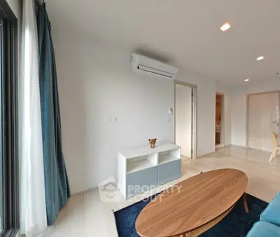 Modern living room with sleek furniture and air conditioning unit, featuring a minimalist design.
