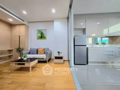 Modern open-plan living room and kitchen with sleek design and natural light.
